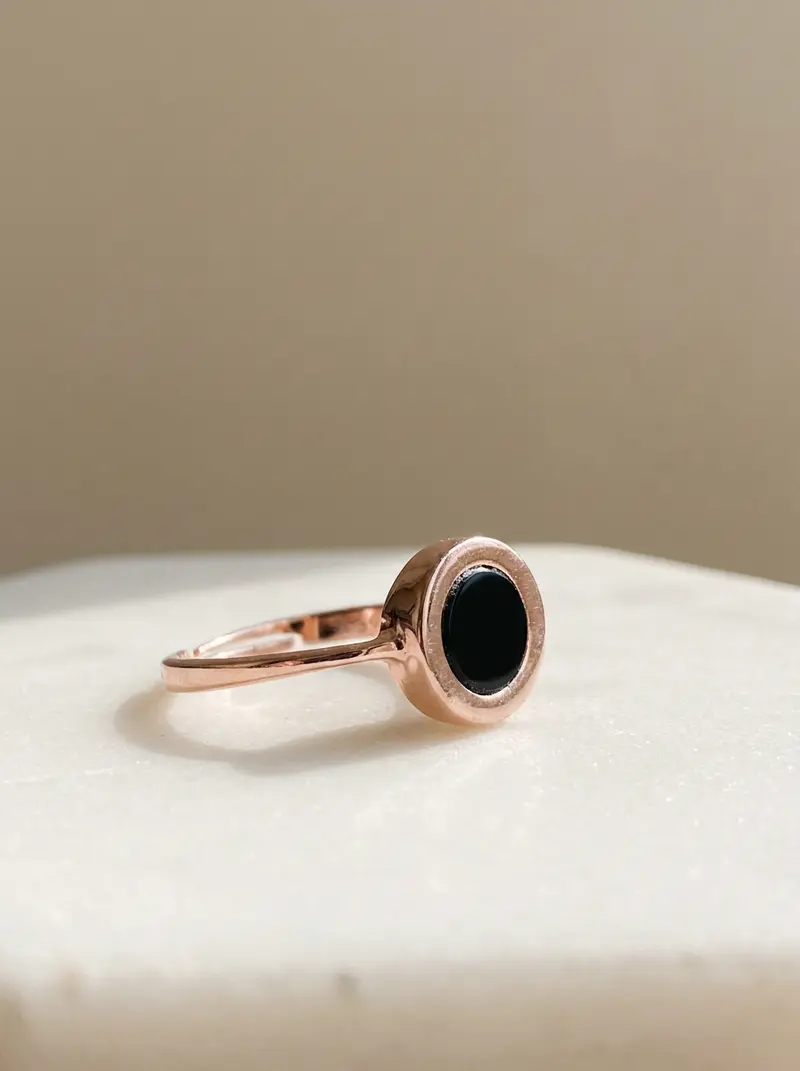 Black onyx round ring resting on an ivory slab