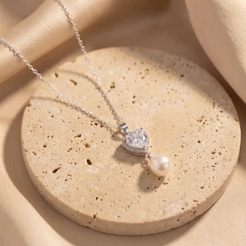 Clear heart and pearl pendant on a travertine disc