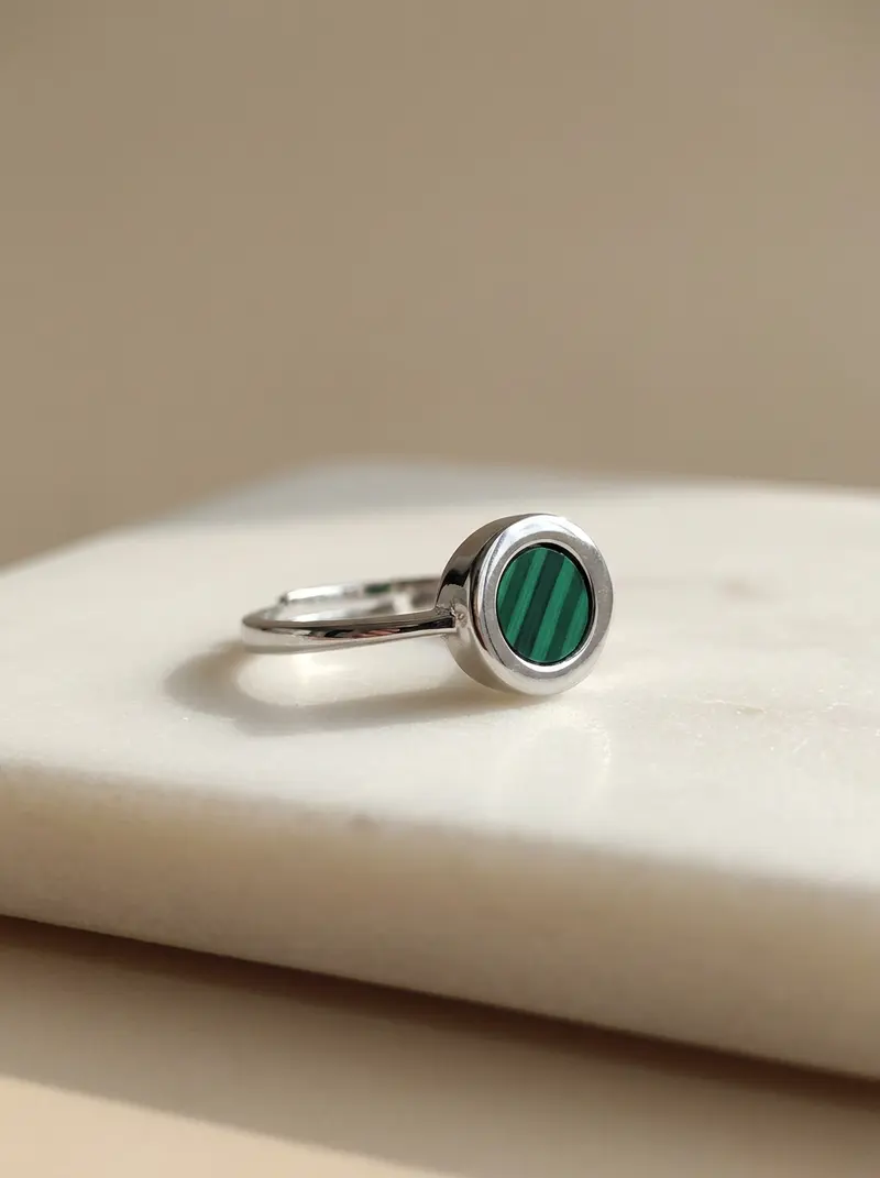 Malachite round ring resting on an ivory slab