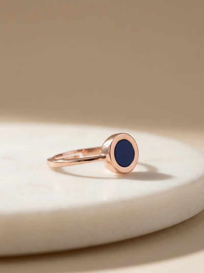 Navy round ring resting on an ivory slab